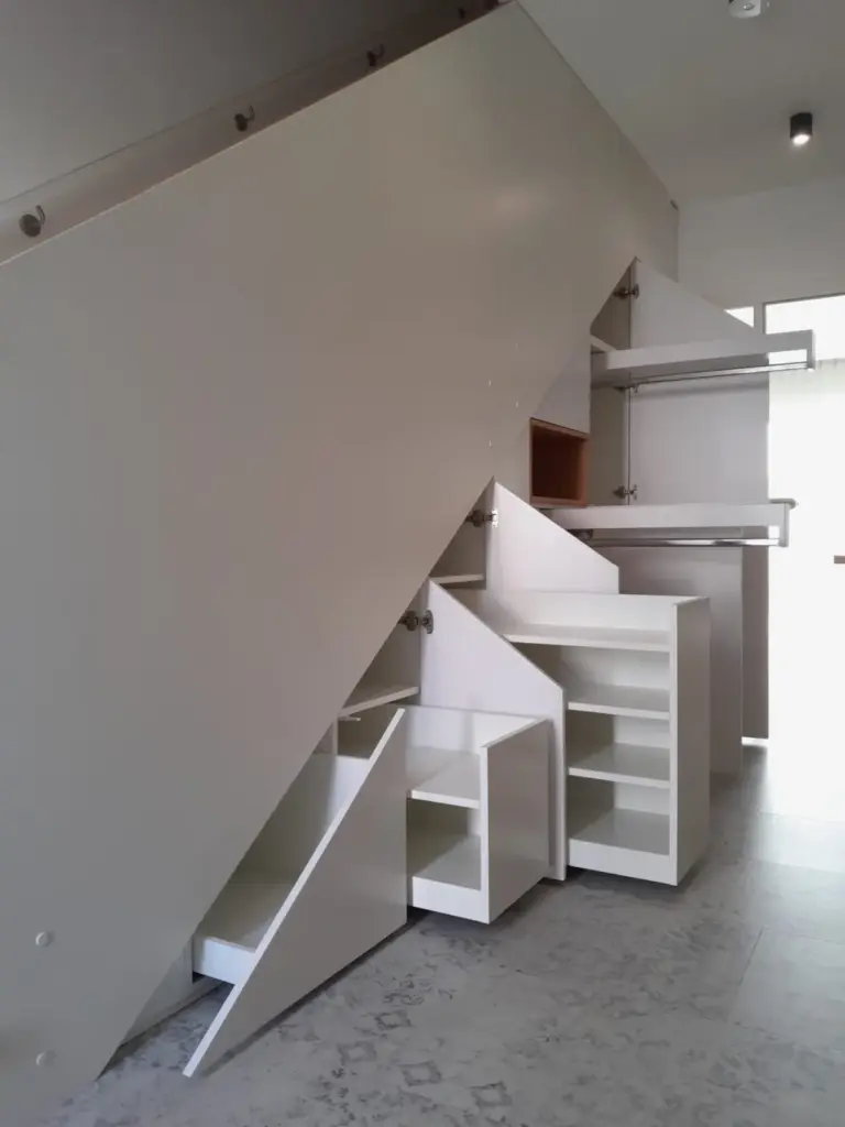 Weißer Treppenaufgang mit bündig angelegten Stauraum auf der Unterseite.